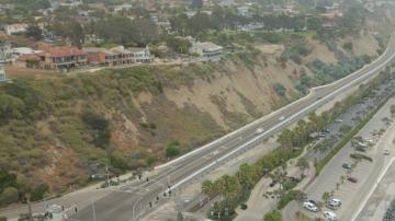 Aerial view of hillside, roadway and beach