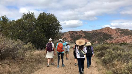 Hikers in Black Star Canyon hiking towards the Red Rock formation