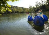 People riding on a large wheeled paddle boat