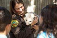 Zoo staff shows children an opossum.